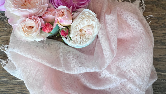 Woven Cashmere scarve with fringe in light pink, shown with pink roses