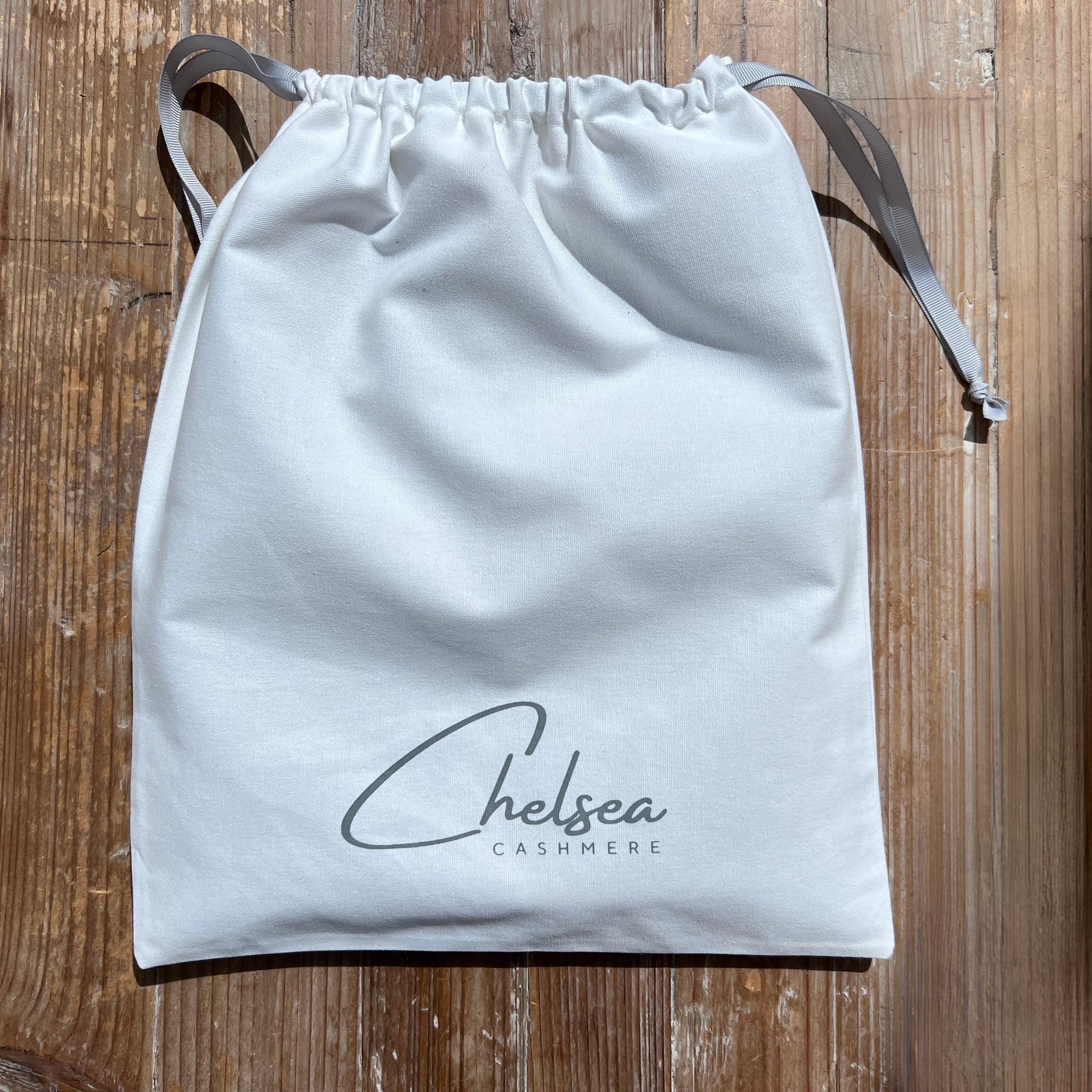 White drawstring bag with 'Chelsea Cashmere' branding