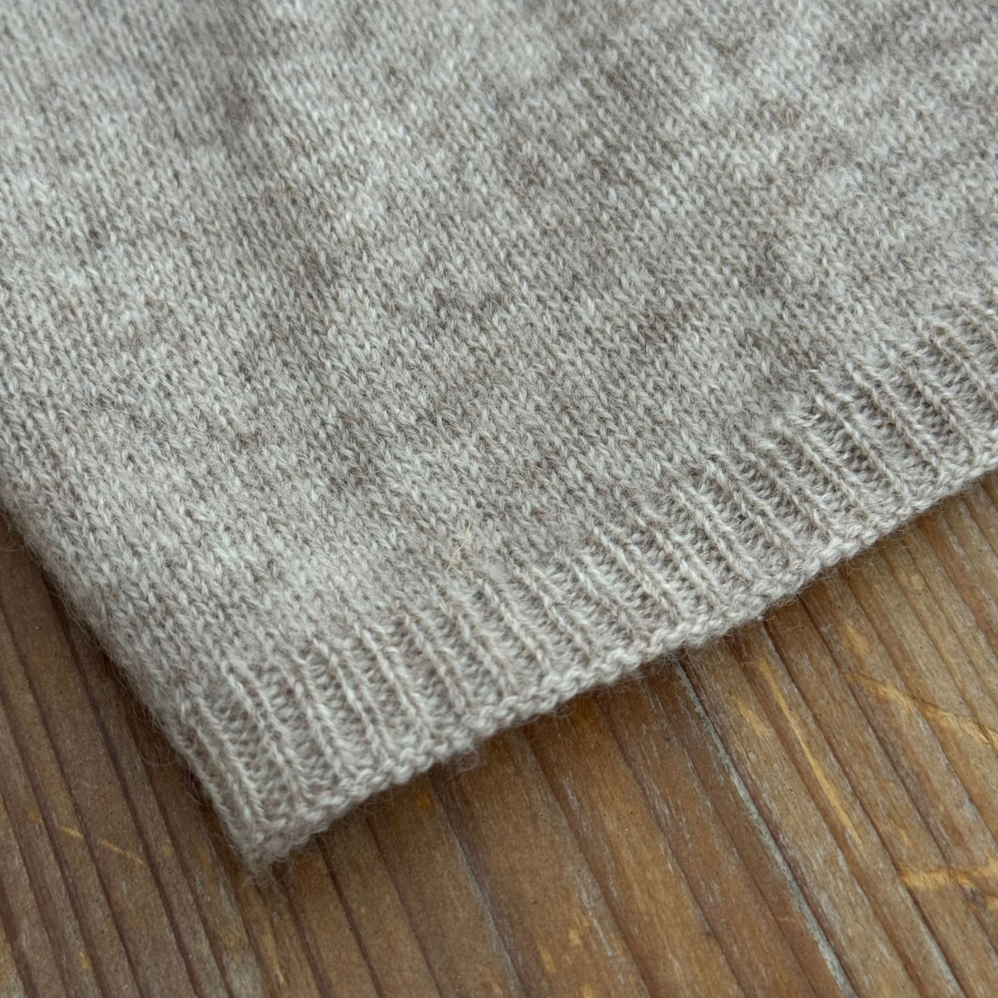 Hem detail of sand beige cashmere travel wrap