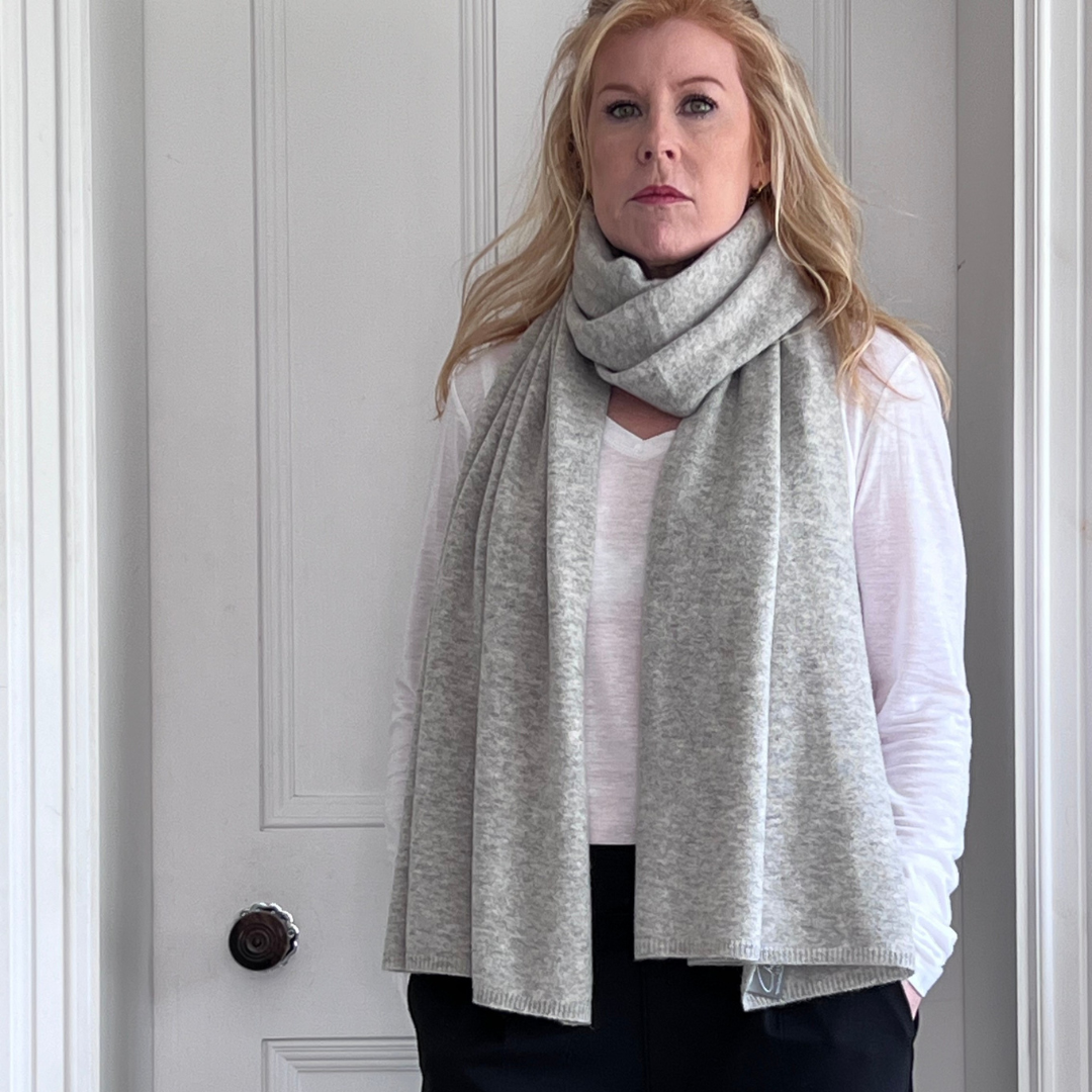 Woman wearing a grey cashmere scarf with smart outfit.