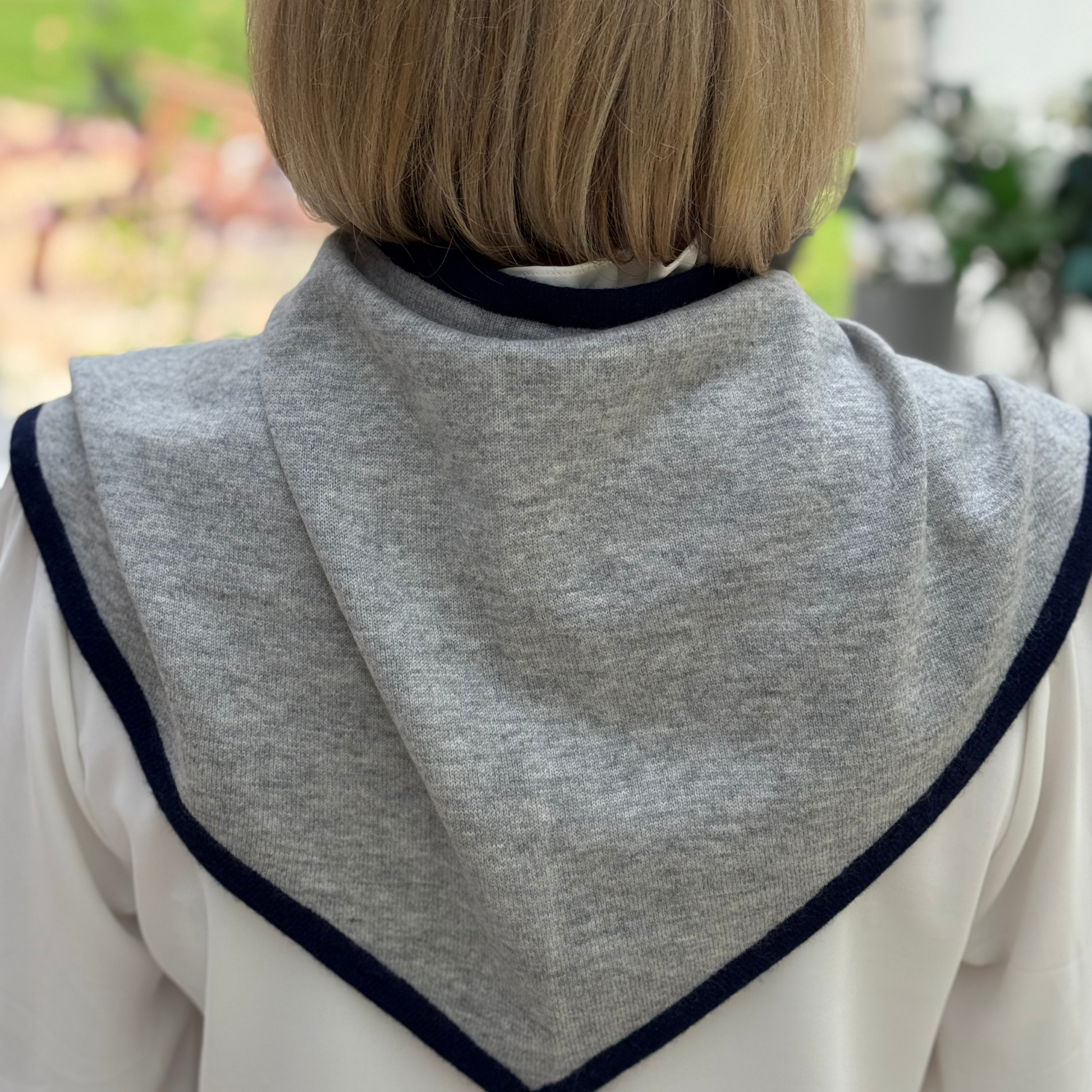 Cashmere Triangle Scarf Light Grey with navy trim worn over shoulders