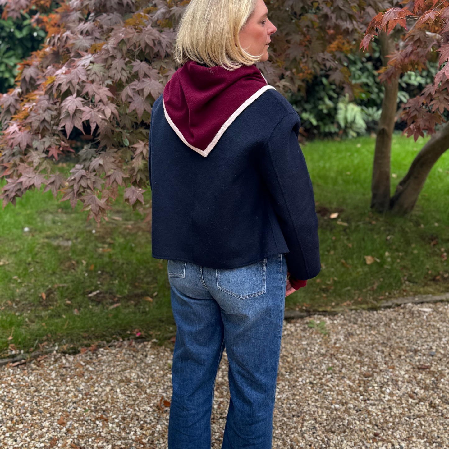 Cashmere Triangle Scarf burgundy with sand beige trim worn over navy blue coat