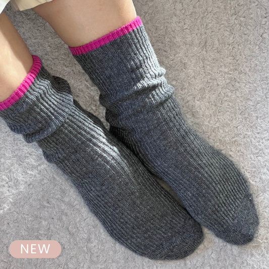 Gray cashmere lounge socks with pink trim worn as cashmere bed socks.